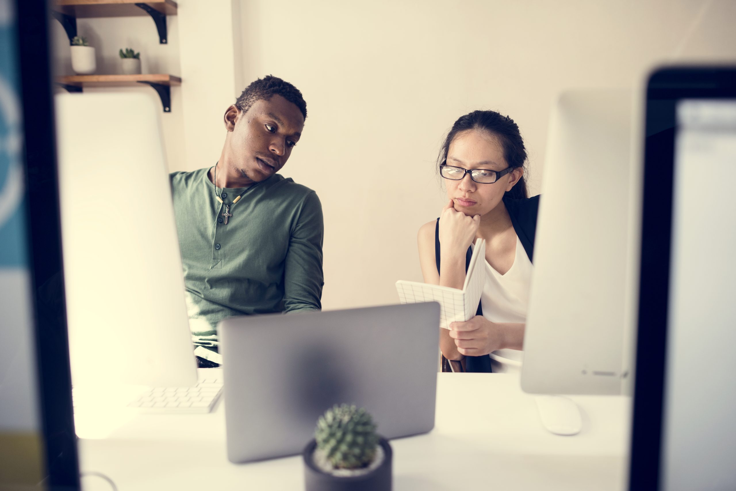 un homme et une femme discutent au bureau